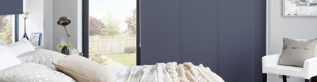 panel blinds of a grey blue colour in a bedroom
